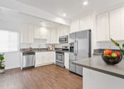 Thumbnail 10 of 61 - a kitchen with white cabinets and stainless steel appliances