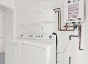 Thumbnail 7 of 10 - a white laundry room with two washers and a dryer