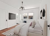 Thumbnail 6 of 10 - a white bedroom with a bed and a tv