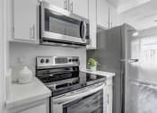 Thumbnail 17 of 66 - a kitchen with white cabinetry and stainless steel appliances