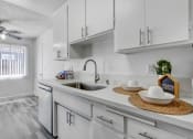 Thumbnail 14 of 66 - a white kitchen with white cabinets and a stainless steel sink