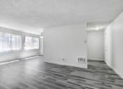 Thumbnail 24 of 66 - an empty living room with wood floors and white walls