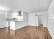 Thumbnail 26 of 31 - the living room and kitchen of an apartment with wood flooring