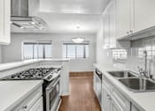 Thumbnail 11 of 31 - a kitchen with white cabinets and stainless steel appliances and a sink
