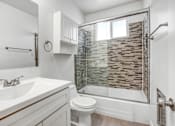 Thumbnail 12 of 31 - a bathroom with a shower and a sink and a toilet
