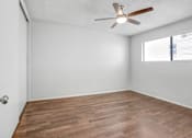 Thumbnail 30 of 31 - an empty living room with a ceiling fan and a window