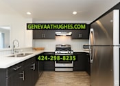 Thumbnail 2 of 28 - A modern kitchen with a stove and refrigerator, and a website address and phone number displayed on the wall.