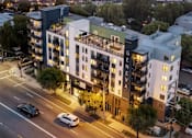 Thumbnail 2 of 163 - A modern apartment building named Generova is situated on a busy street corner.