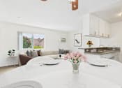 Thumbnail 53 of 81 - A white dining table with a vase of pink flowers on it.