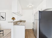 Thumbnail 50 of 81 - A kitchen with a black refrigerator and a marble countertop.