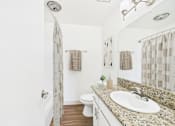 Thumbnail 55 of 81 - A bathroom with a granite countertop and a white sink.