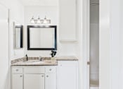 Thumbnail 43 of 81 - A bathroom with a sink, mirror, and cabinets.