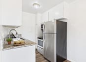 Thumbnail 37 of 81 - A kitchen with a granite countertop and stainless steel appliances.