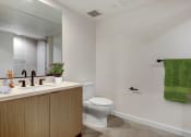 Thumbnail 34 of 38 - a bathroom with white walls and a green towel
