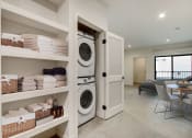 Thumbnail 20 of 38 - a washer and dryer in a laundry room with a table and chairs in the background