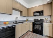 Thumbnail 16 of 38 - a kitchen with wooden cabinets and black appliances