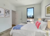 Thumbnail 19 of 38 - a bedroom with a large bed and a door that leads to a balcony