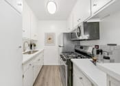 Thumbnail 9 of 24 - a modern kitchen with white cabinets and stainless steel appliances
