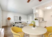 Thumbnail 3 of 24 - a living room and dining room with yellow chairs and a white kitchen
