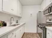 Thumbnail 1 of 24 - a white kitchen with stainless steel appliances and white cabinets