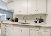 Thumbnail 2 of 24 - a white kitchen with white cabinets and a sink
