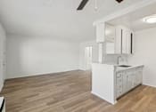Thumbnail 40 of 61 - A kitchen with white cabinets and a wooden floor.
