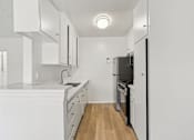 Thumbnail 39 of 61 - A kitchen with white cabinets and appliances.