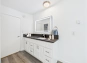 Thumbnail 8 of 76 - A bathroom with a white vanity and a mirror above it.