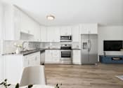 Thumbnail 1 of 76 - A modern kitchen with white cabinets and stainless steel appliances.