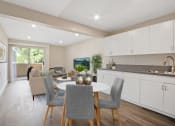 Thumbnail 11 of 52 - a kitchen and living room with white cabinets and a white dining table with grey chairs