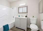 Thumbnail 13 of 52 - a bathroom with a white bathtub and a white toilet next to a sink with a mirror