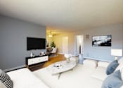 Thumbnail 1 of 9 - A living room with a white couch and a flat screen TV mounted on the wall.