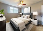 Thumbnail 4 of 9 - A bedroom with a large bed, a ceiling fan, and two lamps.