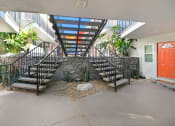 Thumbnail 62 of 66 - the stairway leading up to a building with a red door