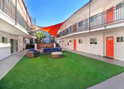 Thumbnail 63 of 66 - the courtyard of a building with a lawn and a red door