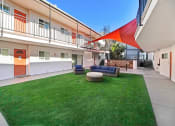 Thumbnail 58 of 66 - the courtyard of a building with green grass and furniture
