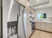 Thumbnail 41 of 66 - a modern kitchen with stainless steel appliances and white cabinets