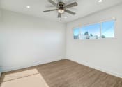 Thumbnail 54 of 66 - an empty living room with a ceiling fan and a window