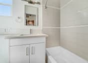 Thumbnail 40 of 66 - a bathroom with a tub and a sink and a mirror