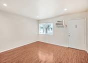 Thumbnail 47 of 79 - Empty room with wood flooring and white walls.