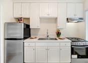 Thumbnail 45 of 79 - A kitchen with white cabinets and a black refrigerator.