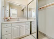 Thumbnail 51 of 79 - A white bathroom vanity with a mirror above it.