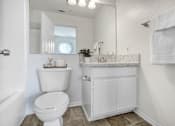 Thumbnail 4 of 11 - a bathroom with a toilet and a sink and a mirror