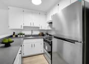 Thumbnail 1 of 46 - a kitchen with stainless steel appliances and white cabinets
