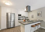 Thumbnail 37 of 76 - Kitchen with stainless steel French door fridge, microwave and breakfast bar with an electric top stove and range hood