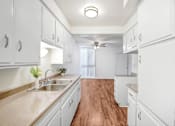 Thumbnail 37 of 48 - a white kitchen with white cabinets and a wood floor