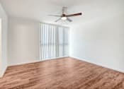 Thumbnail 41 of 48 - an empty living room with wood flooring and a ceiling fan