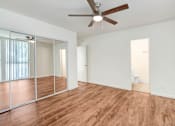 Thumbnail 42 of 48 - an empty living room with a ceiling fan and a mirrored closet