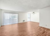 Thumbnail 30 of 48 - an empty living room with wood flooring and a ceiling fan