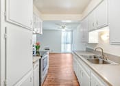 Thumbnail 26 of 48 - a large kitchen with white cabinets and a sink